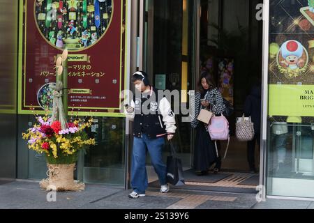 Une décoration kadomatsu japonaise colorée du nouvel an par une entrée du bâtiment Shin-Marunouchi. Il y a de la publicité pour Mario illuminations. Banque D'Images