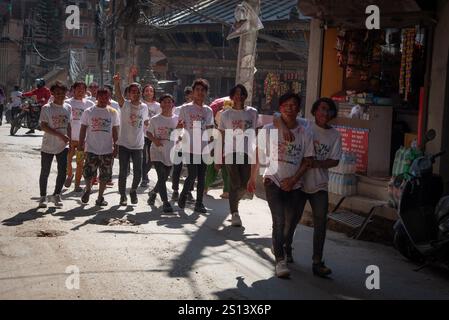 katmandou, Népal, 9 mars 2020 : groupe d'étudiants népalais joyeux célébrant le festival holi, marchant dans la rue couverte de poudre colorée Banque D'Images