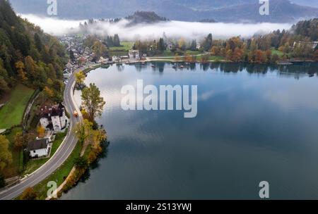 Vue aérienne du brouillard roulant sur l'île de Bled sur le lac Bled, slovénie, pendant un automne coloré Banque D'Images