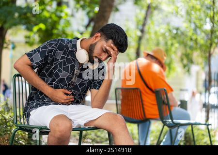 Homme indien se sentant soudainement fort estomac abdominal mal de rein problème de gastrite à l'extérieur. Type hispanique ayant des symptômes empoisonnant diarrhée indigestion ulcère peptique pancréatite dans la rue de la ville. Banque D'Images