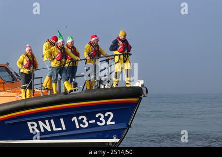 Bateau de sauvetage avec équipage en chapeaux festifs amarré juste à côté de Exmouth Beach avant la natation annuelle du jour de Noël, Devon, Royaume-Uni, le 25 décembre 2024. Banque D'Images