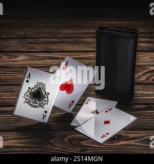 Un jeu de quatre as d'un jeu de cartes à jouer, y compris pique, cœur, trèfle et losange, sont affichés sur une surface en bois à côté d'une carte noire Banque D'Images
