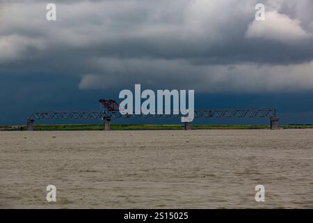 26 juillet 2019 : Munshiganj, Bangladesh : travaux de construction sur le pont polyvalent Padma enjambe le fleuve Padma sous un ciel nuageux. Banque D'Images