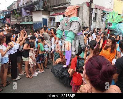 Malabon, Philippines. 31 décembre 2024. Les gens prennent des photos avec leur smartphone pendant que le défilé d'effigie passe. Les habitants de Barangay Tañong à Malabon organisent leur défilé annuel d'effigie la veille du nouvel an. Le défilé présente des effigies remplies de pétards. Crédit : SOPA images Limited/Alamy Live News Banque D'Images