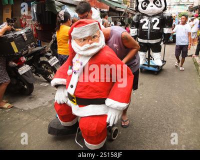 Malabon, Philippines. 31 décembre 2024. Une effigie du Père Noël est défilée dans les rues du Barangay Tañong pour charmer les enfants. Les habitants de Barangay Tañong à Malabon organisent leur défilé annuel d'effigie la veille du nouvel an. Le défilé présente des effigies remplies de pétards. Crédit : SOPA images Limited/Alamy Live News Banque D'Images