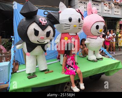 Malabon, Philippines. 31 décembre 2024. Des personnages de la famille Hello Kitty montent dans un chariot lors d'un défilé avec des enfants dessus. Les habitants de Barangay Tañong à Malabon organisent leur défilé annuel d'effigie la veille du nouvel an. Le défilé présente des effigies remplies de pétards. Crédit : SOPA images Limited/Alamy Live News Banque D'Images