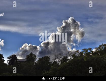 Un nuage d'orage menaçant se développe derrière une maison dans le ciel bleu, formation spectaculaire de nuages, haute Bavière, Bavière, Allemagne, Europe Banque D'Images