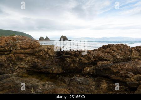 Superbe plage de Diguisit à Baler, Philippines. Il dispose d'une côte accidentée bordée de formations rocheuses et d'un paysage marin serein. La showca au premier plan Banque D'Images