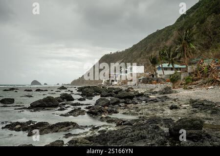 Superbe plage de Diguisit à Baler, Philippines. Il dispose d'une côte accidentée bordée de formations rocheuses et d'un paysage marin serein. La showca au premier plan Banque D'Images
