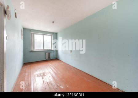 Salon en mauvais état. Chambre sale. Vieux soviétique russe pauvre intérieur. Plancher en bois minable.. Grand angle Banque D'Images