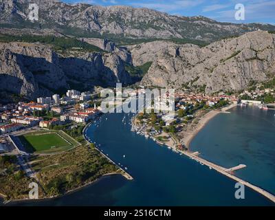 VUE AÉRIENNE. Ville de Omiš à l'embouchure de la rivière Cetina sur la côte montagneuse de l'Adriatique. Comté de Split-Dalmatie, Croatie. Banque D'Images