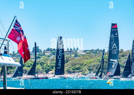 Maxi yachts Master Lock Comanche et Law Connect se bousculent avec d'autres bateaux pour des positions avant le départ de la course de yachts Sydney-Hobart 2024 Banque D'Images