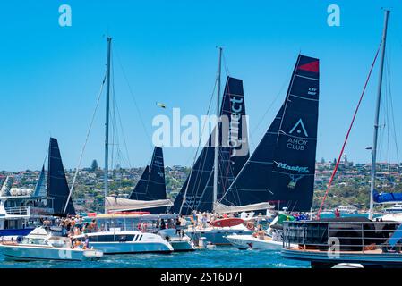 Maxi yachts Master Lock Comanche et Law Connect se bousculent avec d'autres bateaux pour des positions avant le départ de la course de yachts Sydney-Hobart 2024 Banque D'Images