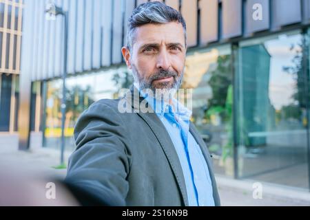 Homme d'affaires confiant prenant un Selfie à l'extérieur Banque D'Images