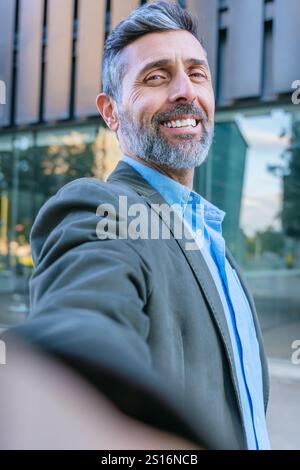 Homme d'affaires confiant prenant un Selfie à l'extérieur. Vertical Banque D'Images