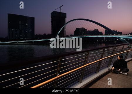 Guangzhou, Chine. 1er janvier 2025. Un touriste vu poser pour une photo au Haixin Brudge à Guangzhou. Le pont Haixin est un pont piétonnier qui a été construit pour relier la rive est de l'île d'Ersha et la tour Canton située au-dessus de la rivière des perles à Guangzhou, en Chine. Crédit : SOPA images Limited/Alamy Live News Banque D'Images