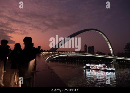Guangzhou, Chine. 1er janvier 2025. Un bateau de tourisme vu flottant dans une rivière des perles à côté du pont Haixin à Guangzhou. Le pont Haixin est un pont piétonnier qui a été construit pour relier la rive est de l'île d'Ersha et la tour Canton située au-dessus de la rivière des perles à Guangzhou, en Chine. Crédit : SOPA images Limited/Alamy Live News Banque D'Images