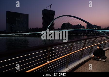 Guangzhou, Chine. 1er janvier 2025. Un touriste vu poser pour une photo au Haixin Brudge à Guangzhou. Le pont Haixin est un pont piétonnier qui a été construit pour relier la rive est de l'île d'Ersha et la tour Canton située au-dessus de la rivière des perles à Guangzhou, en Chine. (Photo de Peerapon Boonyakiat/SOPA images/SIPA USA) crédit : SIPA USA/Alamy Live News Banque D'Images