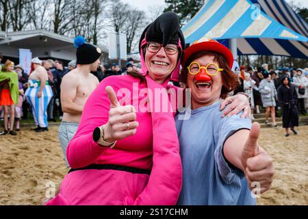 Haltern, Allemagne. 1er janvier 2025. Deux dames se préparent à courir. Les participants, dont beaucoup en costumes, s'amusent à la baignade annuelle du jour de l'an au lac Haltern près de la ville de Haltern am See. Près de 700 participants inscrits, un record pour l'événement, courent à travers la plage de sable naturel du lido du lac et dans l'eau glacée pour prendre un bain et nager pour la charité (cette année, une soupe populaire pour ceux dans le besoin). Plusieurs centaines d'autres sont venus soutenir et regarder les nageurs qui se réchauffent avec du thé, du vin chaud et de la nourriture copieux sur la plage par la suite. Crédit : Imageplotter/Alamy Live News Banque D'Images