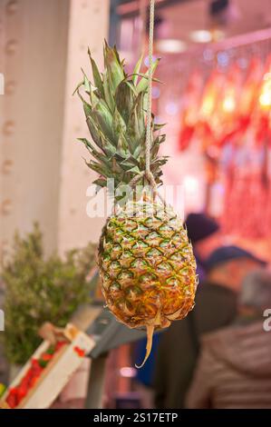 Un ananas suspendu prêt à la vente dans un marché à Valence. Banque D'Images
