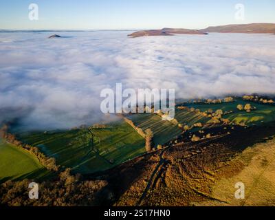 Vue aérienne d'une vallée rurale remplie de brouillard avec des collines ondulantes derrière Banque D'Images