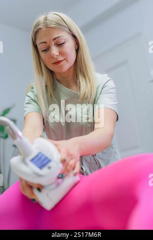 Le masseur se prépare à faire un massage anti-cellulite matériel dans un salon de beauté. Photo de haute qualité Banque D'Images