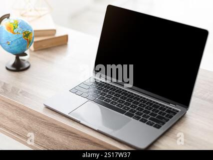 Agent de voyage féminin utilisant un ordinateur portable avec écran vide dans le bureau Banque D'Images