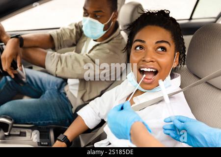 Black Woman testé pour Covid-19 assis en mode Auto Banque D'Images