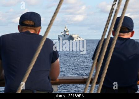 Deux membres d'équipage à bord du Coast Guard Cutter Eagle (Wix 327) voient les navires de la marine française FS Tonnerre (L9014) et FS Guépratte (F714) dans les Caraïbes, le 7 juin 2024. Les trois navires ont mené une cérémonie de passage où ils se sont rendus des honneurs au large de la Colombie. (Photo de la Garde côtière américaine par le premier maître de 1re classe Matthew West) Banque D'Images