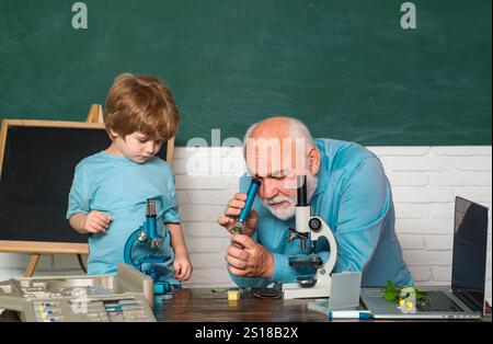 Retour à l'école et Happy time. Professeur drôle dans la salle de classe. Microscope de laboratoire et sciences biologiques pour les enfants. Biologie - la classe des sciences Banque D'Images