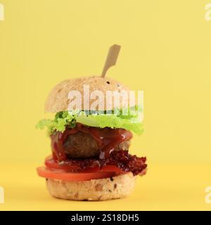 Mini hamburger avec Burger de bœuf, laitue et tomate, sur fond jaune Banque D'Images