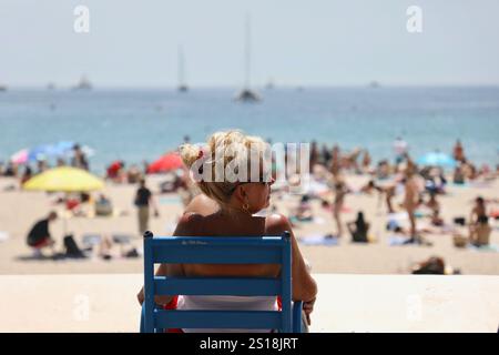 Une femme prend un bain de soleil sur la célèbre Promenade de la Croisette pendant le Festival de Cannes 2022. Le Festival de Cannes 2022, 75ème édition a eu lieu du 17 au 28 mai 2022 à Cannes. Le président du jury était l'acteur français Vincent Lindon. Le film Triangle of Sadness de Ruben Östlund a remporté la Palme d'Or qui est le plus haut prix décerné par le festival. Banque D'Images