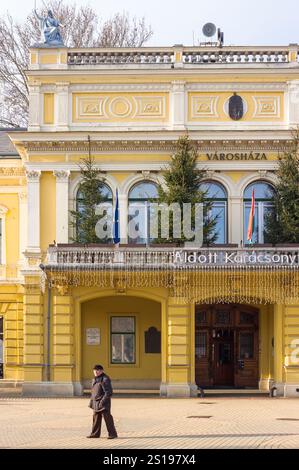 nyiregyhaza, hongrie - 07 dec, 2014 : hôtel de ville sur les vacances d'hiver. paysage urbain européen. temps ensoleillé. drapeaux et arbres de noël sur le balcon. Banque D'Images