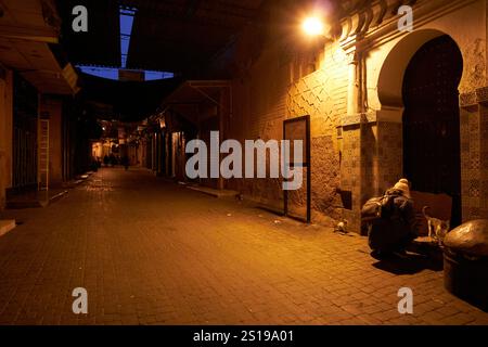 étroite ruelle vide dans la vieille ville médina tôt le matin avant que tous les magasins ouvrent avec femme nourrissant les chatons à la mosquée des chatons souk laksour marr Banque D'Images