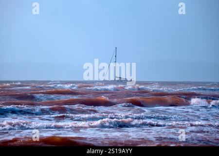 Yacht au large de la plage d'Exmouth, Devon Royaume-Uni dans une mer agitée. Banque D'Images