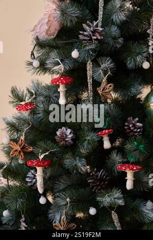 Arbre de Noël fantaisiste orné de champignons décoratifs et de pommes de pin pour la saison des fêtes Banque D'Images