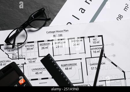 Différents dessins architecturaux, verres, calculatrice et règle sur table texturée grise, pose à plat Banque D'Images