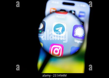29 décembre 2024, basse-Saxe, Norden : le logo de l'application Telegram est visible à travers une loupe sur l'écran d'un smartphone le 29 décembre 2024. Telegram est un service de messagerie instantanée gratuit du développeur Telegram FZ-LLC pour une utilisation sur smartphones, tablettes, smartwatches et PC, qui a été développé en Russie. Par défaut, les chats ne sont cryptés qu'entre le client et le serveur ; les chats entre deux personnes peuvent éventuellement être cryptés de bout en bout en tant que « chats secrets ». Photo : Matthias Balk/dpa Banque D'Images