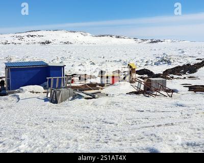Cabanes et hangars au camp de chasse/pêche sur la plage de Frobisher Bay à Apex, Nunavut, Canada Banque D'Images