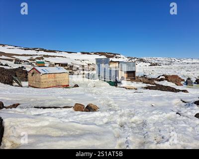 Cabanes et hangars au camp de chasse/pêche sur la plage de Frobisher Bay à Apex, Nunavut, Canada Banque D'Images