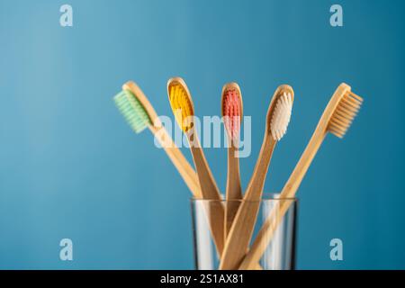 Ensemble de brosses à dents en bambou coloré en verre sur fond bleu, gros plan. Zéro déchet, sans plastique, concept de produit organique respectueux de l'environnement Banque D'Images