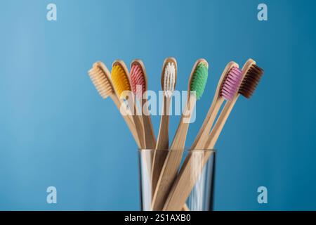 Ensemble de brosses à dents en bambou coloré en verre sur fond bleu, gros plan. Zéro déchet, sans plastique, concept de produit organique respectueux de l'environnement Banque D'Images