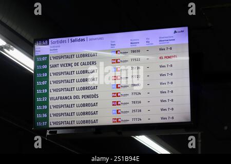 Barcelone, Espagne - 21 décembre 2024 : panneau numérique de départ des trains affichant les horaires pour différentes destinations en Catalogne Banque D'Images