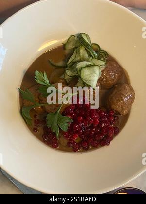 Boulettes de viande suédoises traditionnelles servies avec sauce crémeuse, airelles et concombre mariné dans un bol blanc Banque D'Images