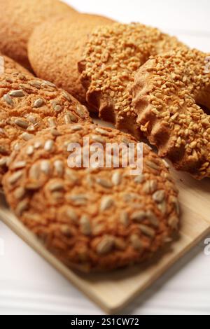 Biscuits assortis avec graines de tournesol et garnitures croquantes affichés sur un plateau en bois Banque D'Images