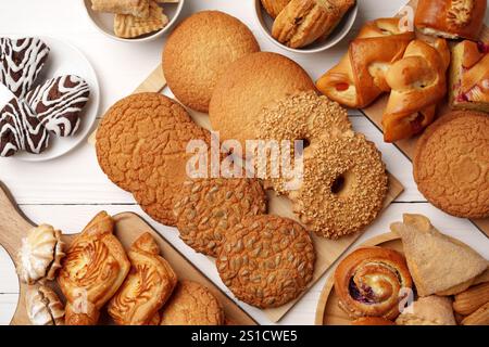 Assortiment de produits de boulangerie affichés sur des planches et des assiettes en bois dans une boulangerie confortable dans la lumière du soleil de l'après-midi Banque D'Images