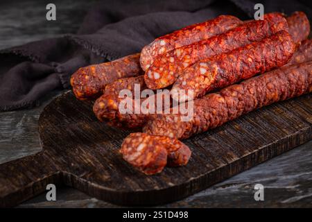 Bâtonnets de saucisse au paprika fumé sur une planche de bois, hors-d'œuvre et en-cas de charcuterie Banque D'Images