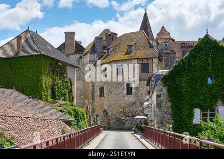 Vue sur le village médiéval de Carennac dans le Lot Occitanie Sud de la France depuis le pont sous un ciel bleu avec des nuages en été Banque D'Images