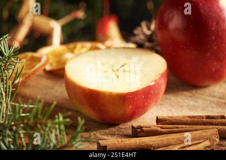 Pomme coupée en deux avec une étoile au milieu, cannelle et branches d'arbre de Noël Banque D'Images