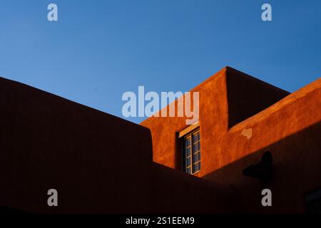 Le coucher de soleil à Santa Fe, Nouveau-Mexique, se reflète sur un bâtiment de style adobe le jeudi 2 janvier 2025. Banque D'Images